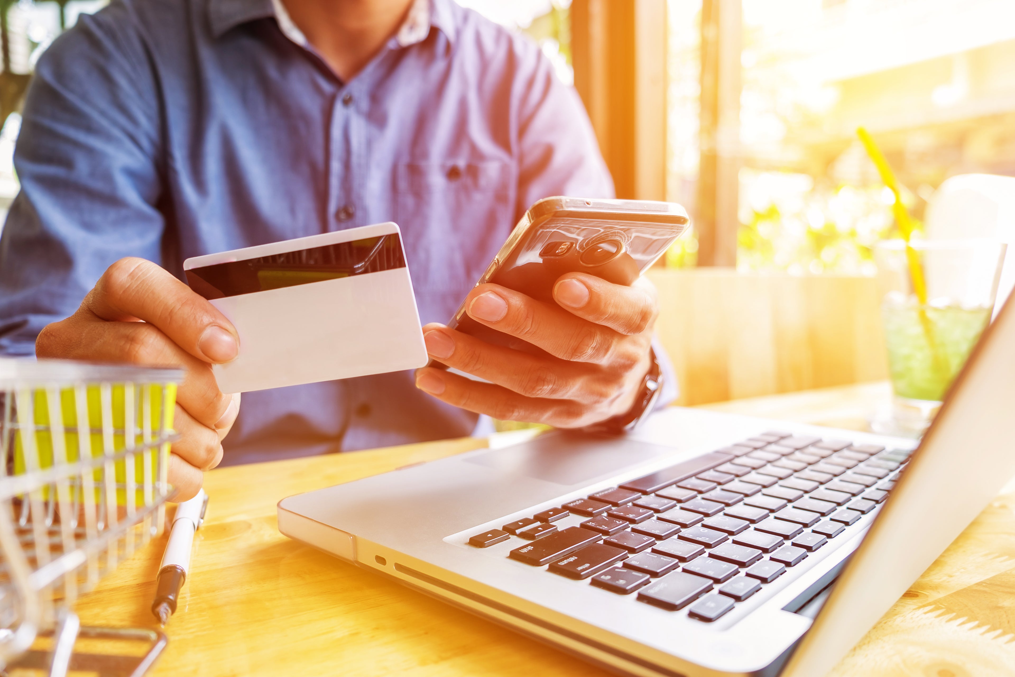 man-holding-credit-card-hand-entering-security-code-using-laptop-keyboard